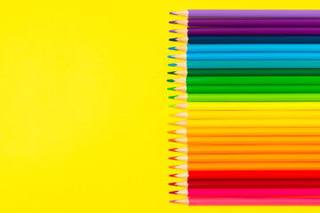 Colored pencils on a bright colored background. Equipment for coloring. Stationery for...