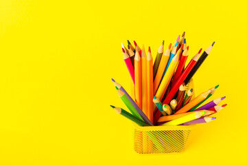 Colored pencils on a bright colored background. Equipment for coloring. Stationery for...
