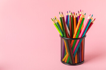 Colored pencils on a bright colored background. Equipment for coloring. Stationery for...