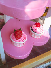 Two Cupcakes with Pink Cream Frosting, Strawberry and Cherry Topping