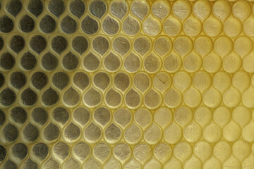 Texture glass wall partially illuminated in brilliant sunlight consists of repeating...