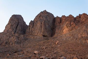 Fototapeta premium Rocky mountain cliffs at sunset in Yazd, Iran, showcasing rugged desert landscapes and dramatic geology ideal for nature, adventure, and travel photography.