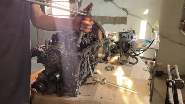 unscrewing the bolts on the engine with a special key. High quality 4k footage