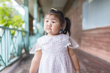 A cute little Asian girl is looking up curiously,Young little girl with a curious expression,...