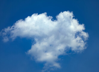 A lonely light cloud hovering above the ground on a dark blue background. Looking up at the sky in hopes of a sign from above. Gradual sailing with the wind in search oneself. Meditative picture.