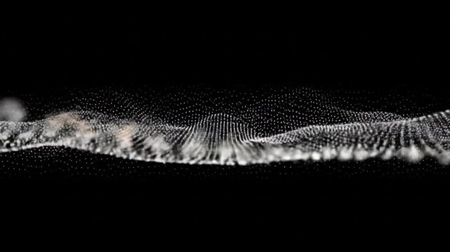 White dots forming a wave like pattern against a black background in a studio shot