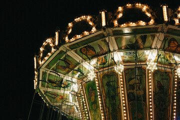 Children's carousels lit up. Luna Park. Evening or nighttime amusement park.