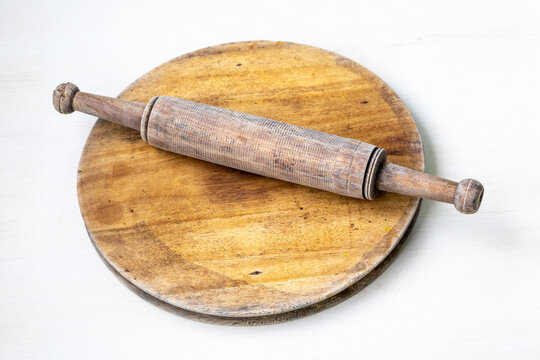 Wooden rolling pin and board on white background. Traditional Bangladeshi chapati and roti maker. Essential kitchen tool.