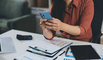 Closeup image of a businesswoman using mobile phone in office