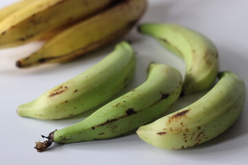 Raw and ripe Nendran plantains in bunches, showing ripening stages. Good for harvest and food themes