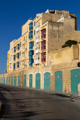 Obraz premium A building full of colorful traditional balconies and green gates in Valletta