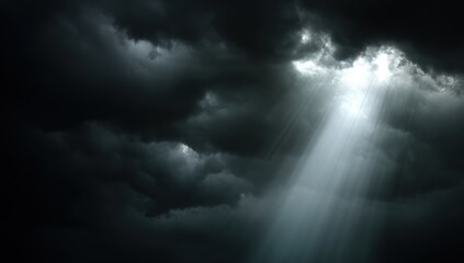 Obraz premium Sunlight piercing a dark sky filled with clouds.