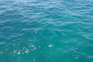 Blue sea water surface and ripples on waves background. Summer abstract reflections