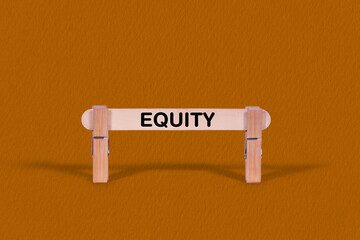 Equity symbol. Wooden stick tightened by Clothespins, beautiful Orange color Backdrop. Business and Equity concept with copy space