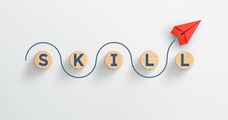 Red paper plane with SKILL words icon on wooden cubes. Upskilling and personal development concept.