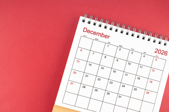 December 2026 desk calendar on red color background. Flat lay.