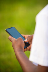 Black African male person Hand holding mobile phone typing in daytime outside, social media, news, entertainment, vertical portrait view