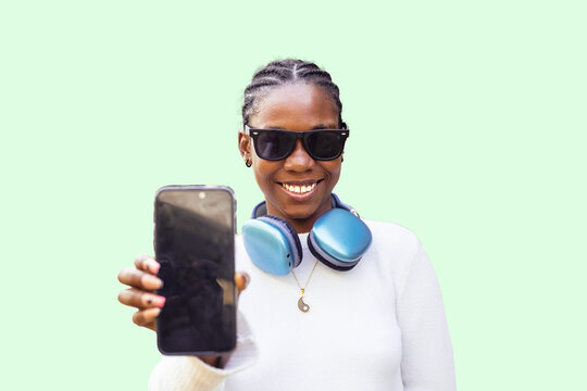 Smiling woman with sunglasses holding a smartphone