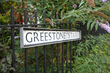 Lincoln, Lincolnshire, England – August 21 2025: Greenstone stairs sign surrounded by summer...