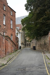 Lincoln, Lincolnshire, England – August 21 2025: Historic cobblestone lane with medieval architecture and stone walls in Lincoln, England.