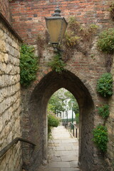 Lincoln, Lincolnshire, England - August 21 2025: View of a medieval archway and cobblestone path...