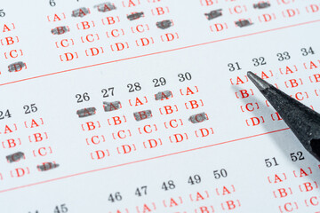 A close-up shot of an answer sheet with pencil marks, showing the process of taking an exam or...