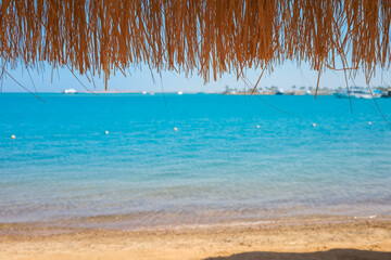 Straw umbrella overlooking the turquoise Red Sea in Egypt