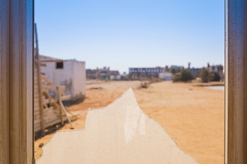 Broken window with desert landscape view