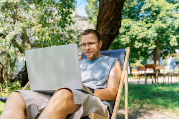 Freelancer working on laptop outdoors in park