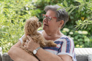 Frau mit Maltipoo auf der Terrasse
