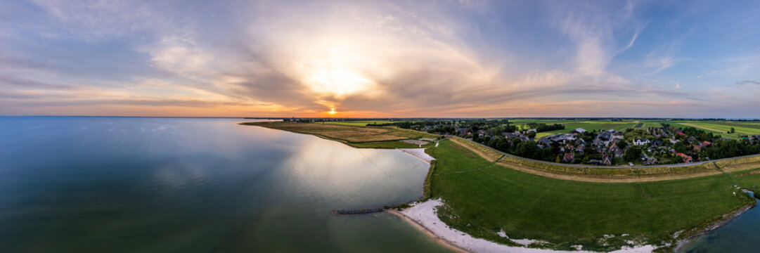 Serene beauty of a small beach on Markermeer lake in Schellinkhout the Netherlands during sunset. The tranquil scene features lush meadows, houses, and the gentle evening light. Aerial Panoramic view
- Powered by Adobe