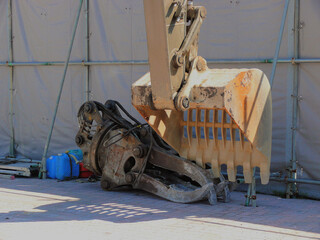Iron arms of heavy machines prepared at the corner of the construction site.