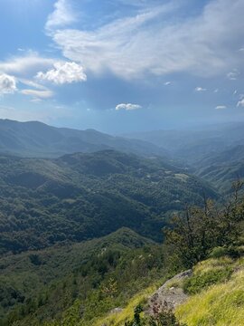 Panoramic Mountain View from Castagno d&rsquo;Andrea, Lush Green Forests and Rolling Hills under a Lightly Clouded Sky in Tuscany&rsquo;s Apennine Region, Capturing the Natural Beauty of Central Italy