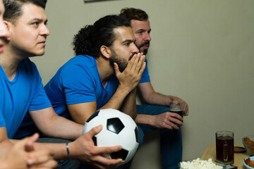 Soccer fans watching game holding ball and drinking beer