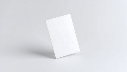 Minimalist mockup of a blank white vertical business card standing on a clean, light gray background with a soft shadow.