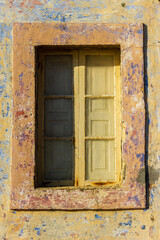 Weathered Rustic Window Set Against Peeling Painted Wall In Warm Sunlight