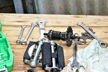 Bicycle repair. Metalworking tools and bicycle parts are on the table in the workshop.