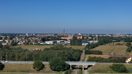 Expansive Panorama of Italian Industrial Landscape Showcasing Data Center Facilities and Cloud Storage Infrastructure Amidst Rolling Hills Under a Clear Blue Sky in Lombardy