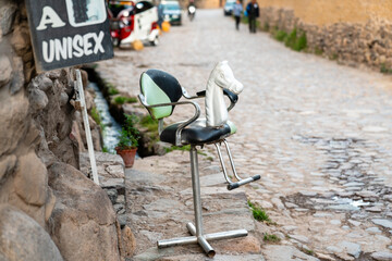 Ein Friseurstuhl mit einem weißen Pferdekopf auf einer Gasse in Ollantaytambo, Peru