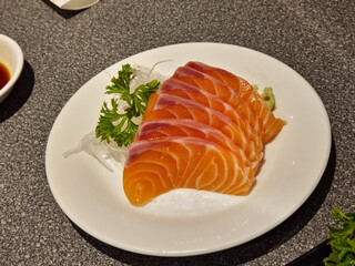 Salmon sashimi on a plate, top view image.