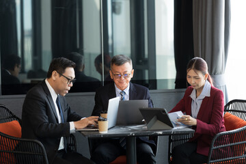 Asian business people meeting and discussing project planing with laptop computer in modern office. Collaboration and exchange of opinions, share ideas, and plan work together. brainstorming, teamwork