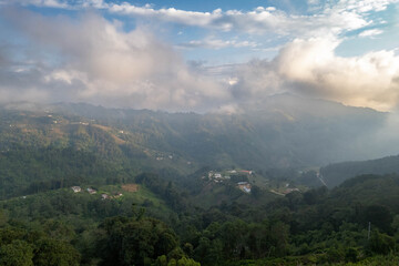 Aerial panoramic view of Lake Atitlán and San Pedro in Guatemala with volcanic mountains, lush green landscape, and dramatic sky over Central America