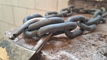 Heavy chain and padlock securing a concrete surface, close-up view