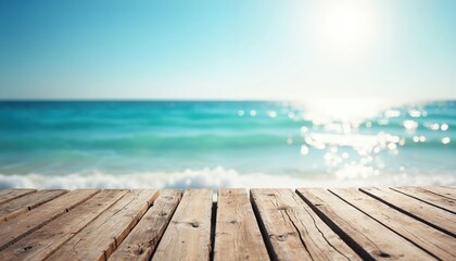 Serene beach scene with wooden pier extending into ocean. Calm water reflects clear blue sky. Light brown planks create sense of depth. Small waves gently lap against shore.