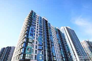 A very tall building featuring numerous windows set against a blue sky