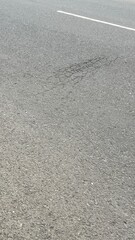 Close-up of asphalt road surface featuring a small crack