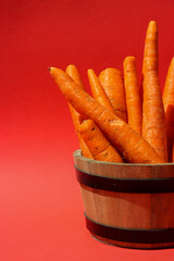 Fresh picked carrots in a wooden bowl.