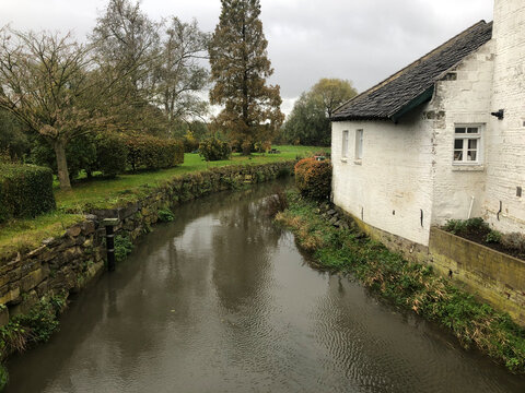 Small Canal Along a White Brick House in Maastricht &ndash; Typical Limburg Architecture Framed by Autumn Greenery, Capturing the Quiet Charm of the Dutch Countryside in the Heart of the City
