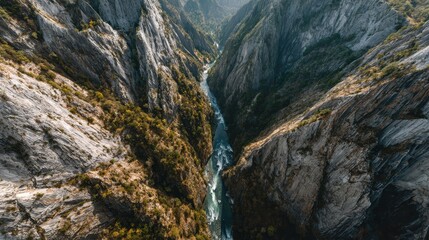 Aerial view of river canyon, steep cliffs, autumn foliage, background mountains; travel brochure