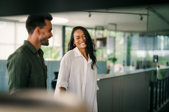 Cheerful diverse coworkers having fun during work break using technology enjoying working together